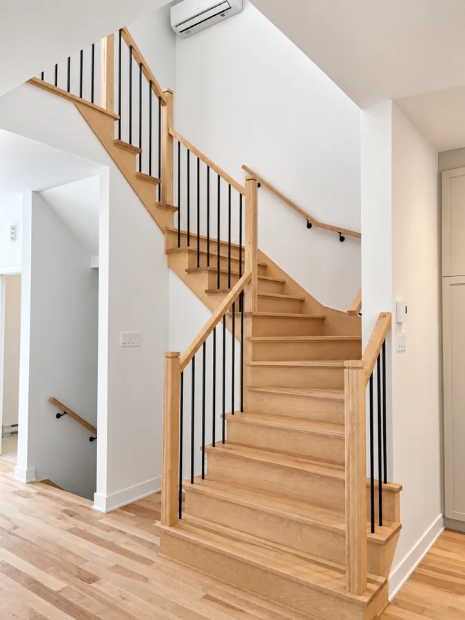 Escalier tournant en bois et barreaux noirs